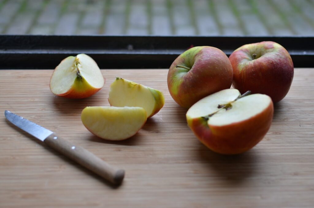苹果切片接近两个红苹果并刀与木柄